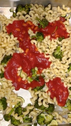 Pour in a can of tomato sauce, oregano, and chili flakes.