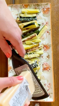 Grate parmesan on top of zucchini