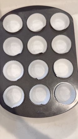 adding muffin liners to the tin