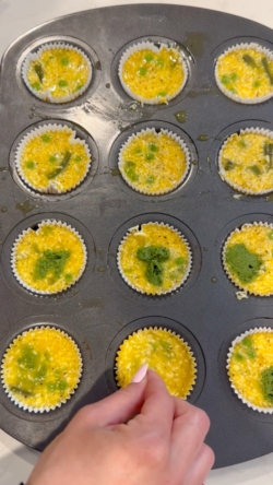 adding dollops of pesto into muffin liners