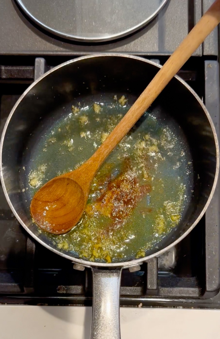 adding garlic, turmeric, and cinnamon to pot